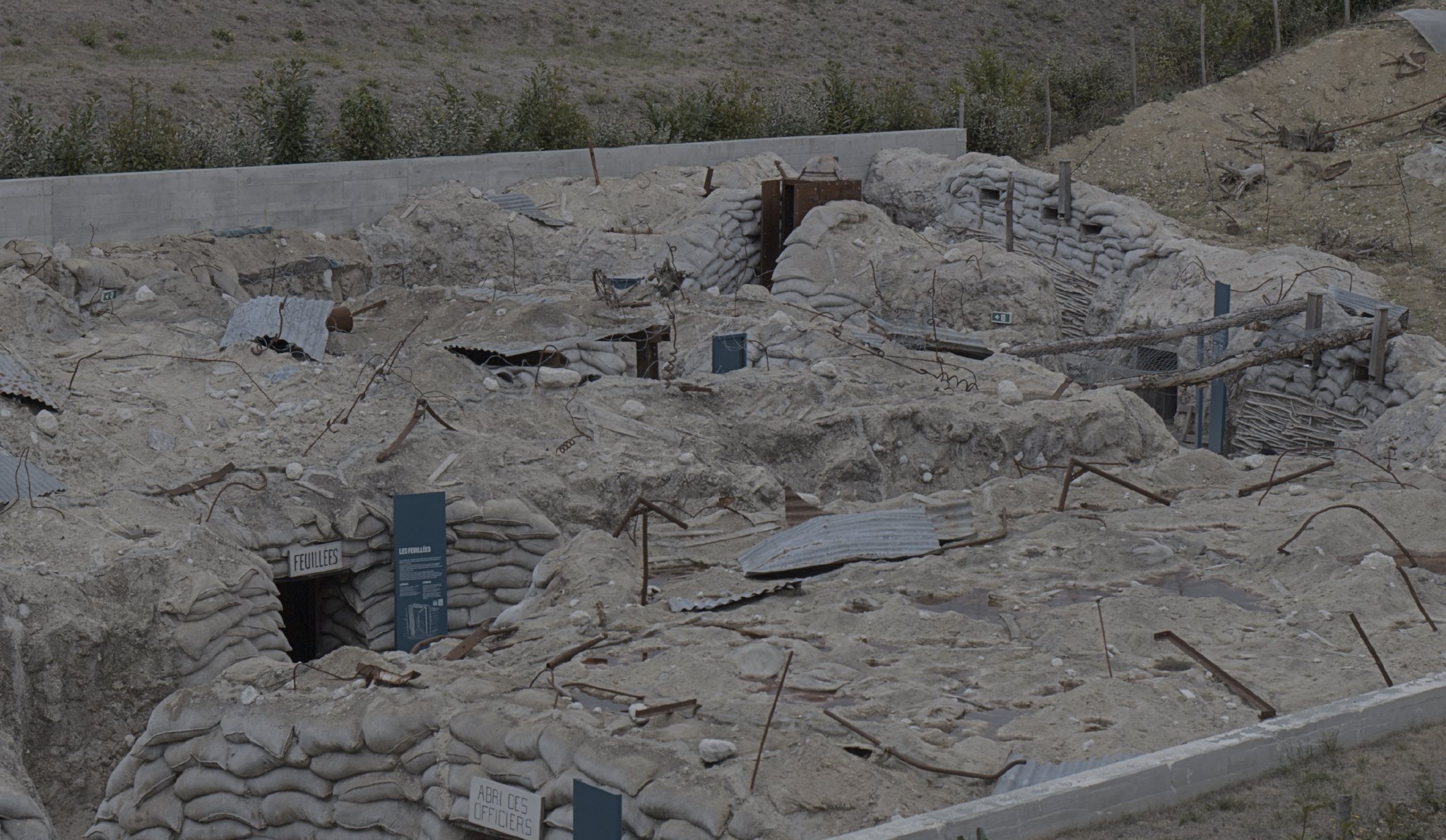 Reconstitution de tranchées, sacs de sable et tôles, dans le parc du musée